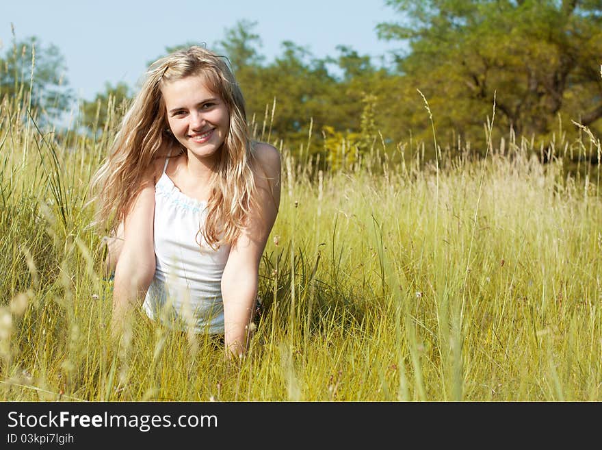 Beautiful young woman in a green field