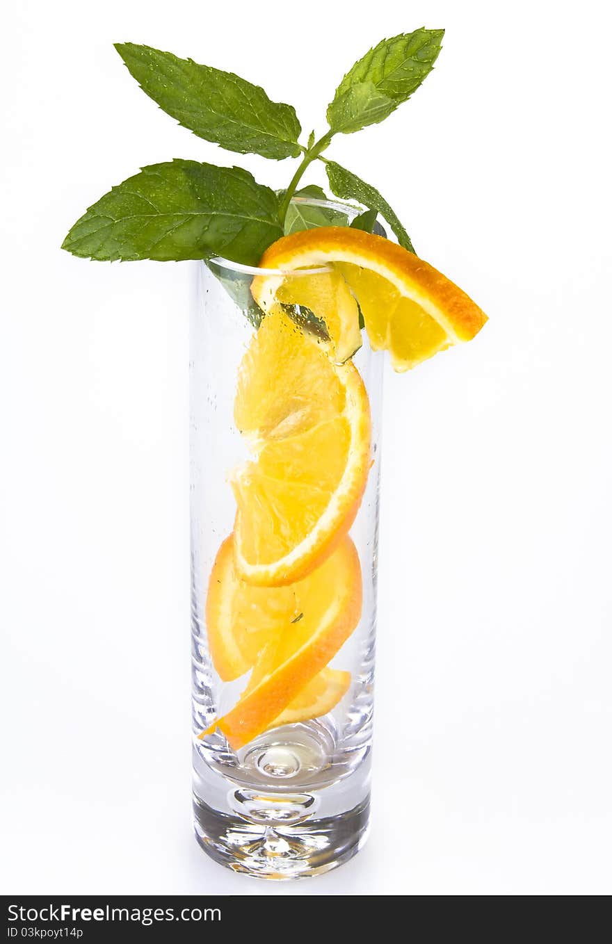 Slices of orange and mint in the glass isolated over white. Slices of orange and mint in the glass isolated over white