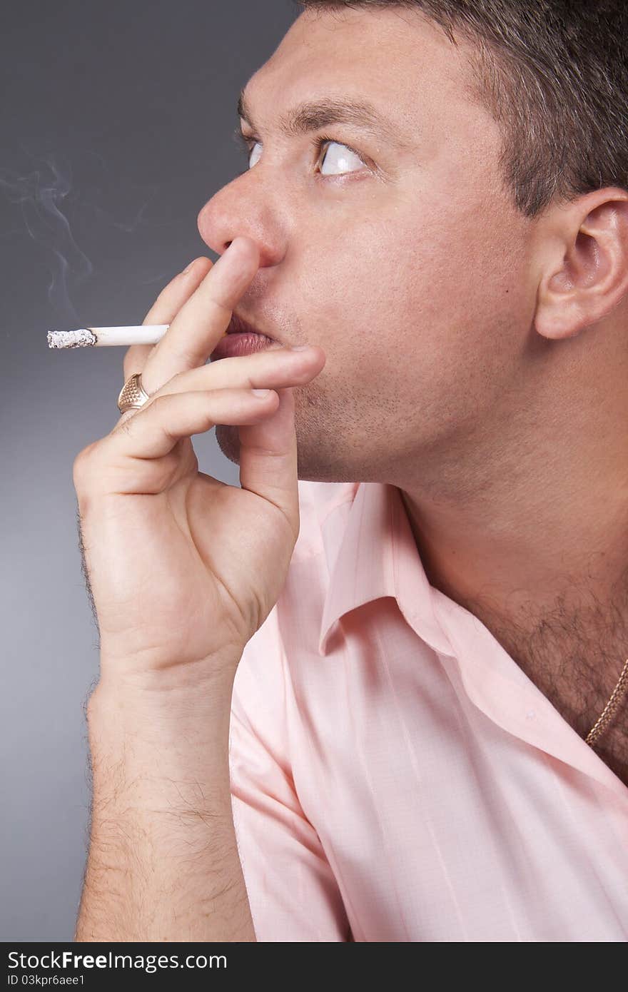 A portrait of a young man smoking a cigarette