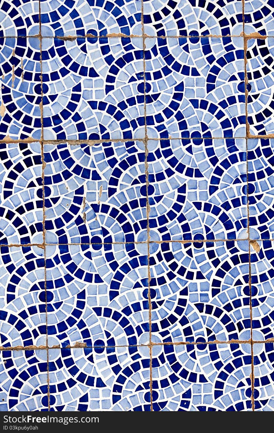 Close up view of a broken tiled wall of small azulejo.