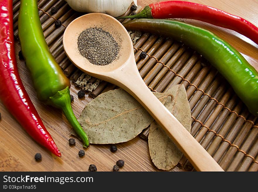 Some kinds of pepper and bay leaf on wooden plate. Some kinds of pepper and bay leaf on wooden plate