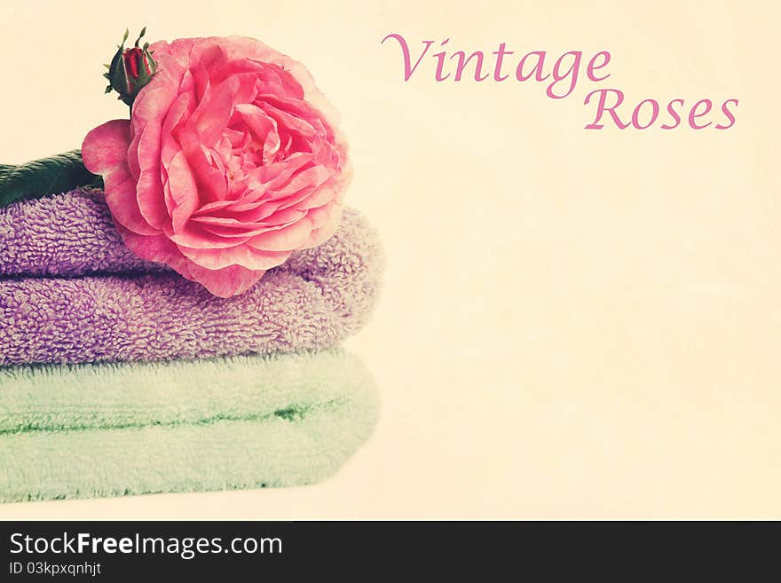 Stacked colorful towels with roses flower. Isolated over white