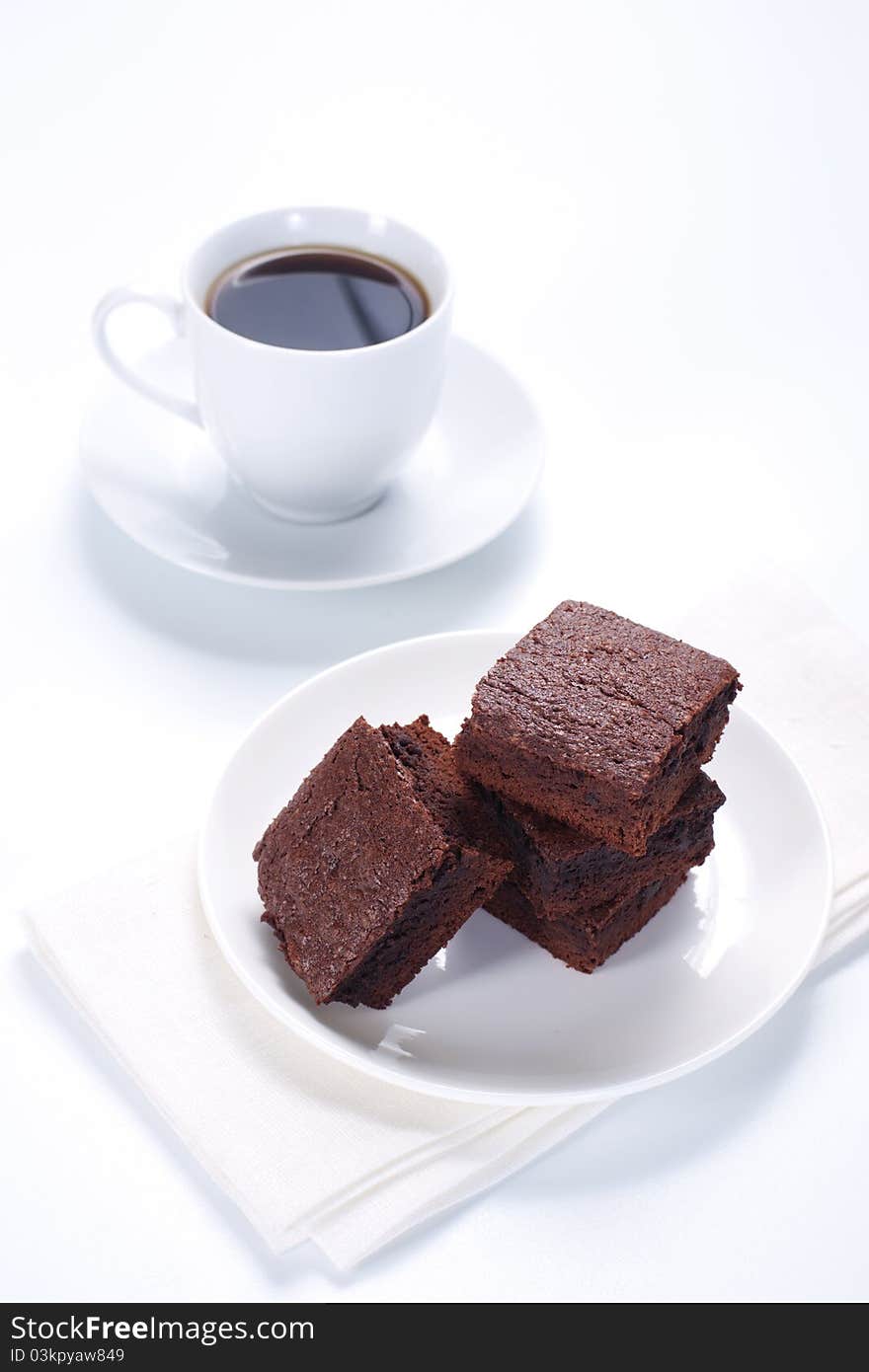 Chocolate brownies on the cake stand and cup of cofee