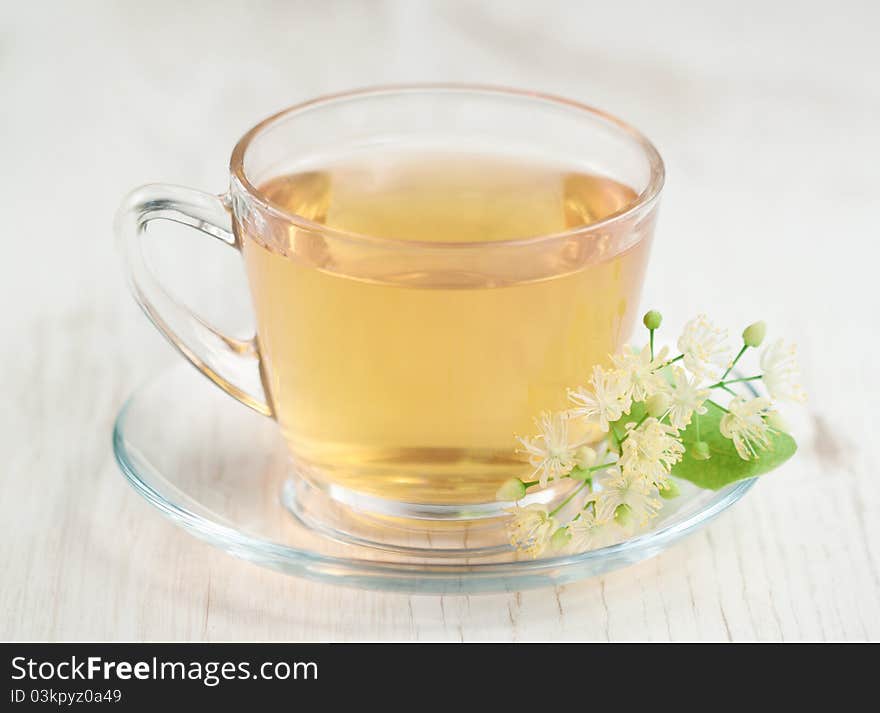 Cup of tea and linden flowers on wooden background. Cup of tea and linden flowers on wooden background