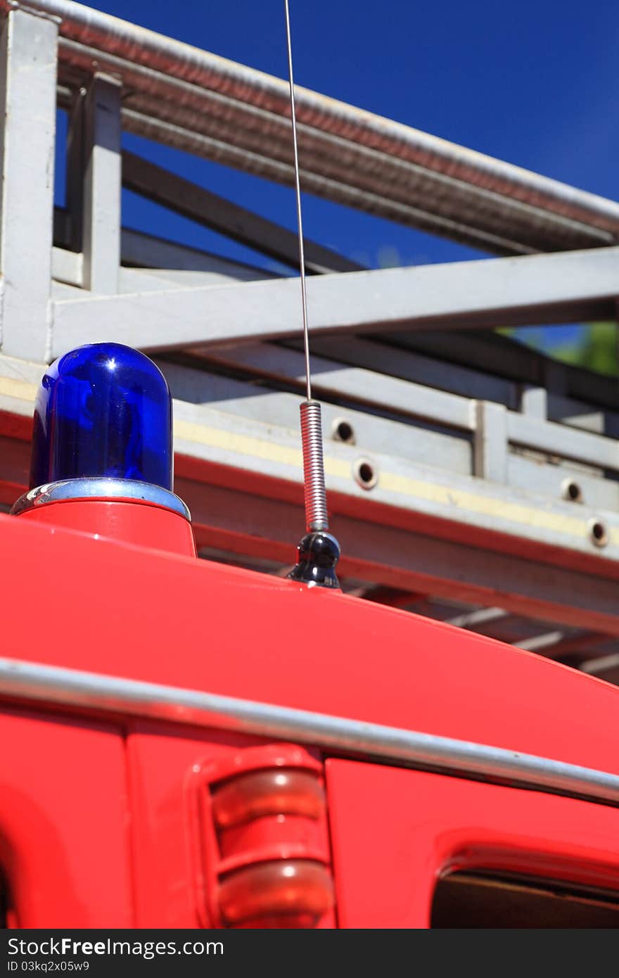 Ladder of a fire truck on the blue sky, emergency light on firetruck