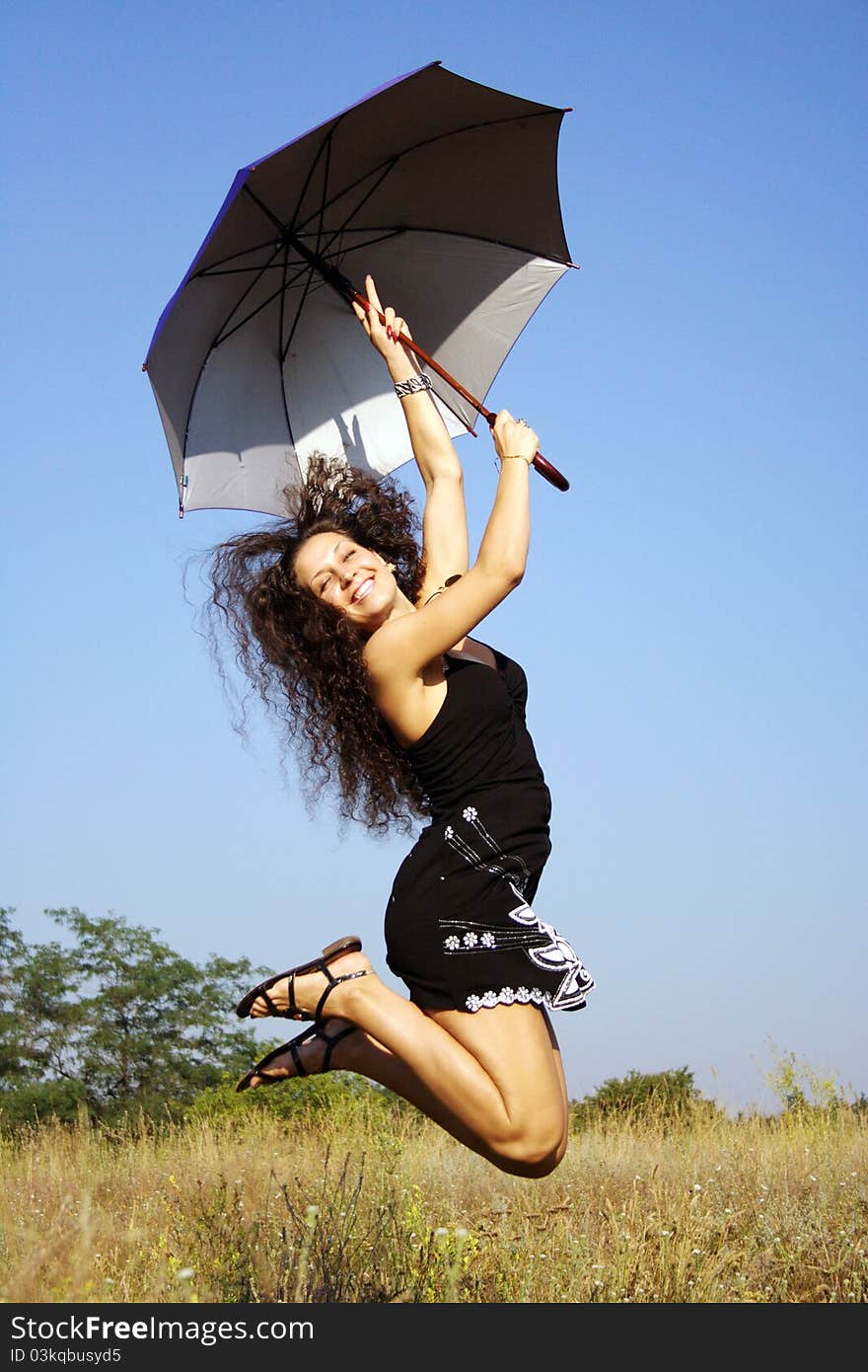 Happy girl jumping with umbrella