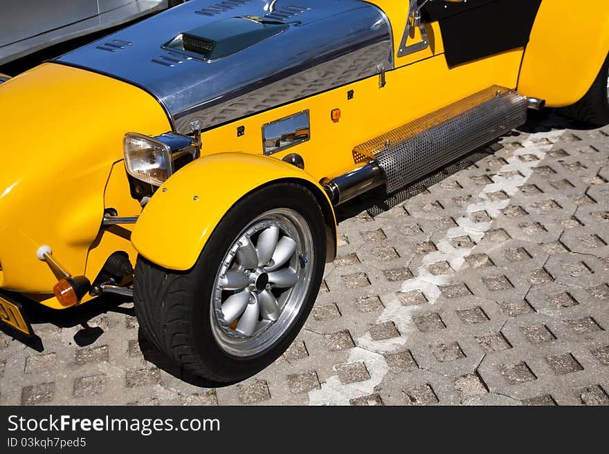 Close view of a weird yellow sports car parked on a park. Close view of a weird yellow sports car parked on a park.