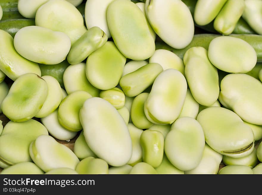 Close up view of some broad beans on a white background.