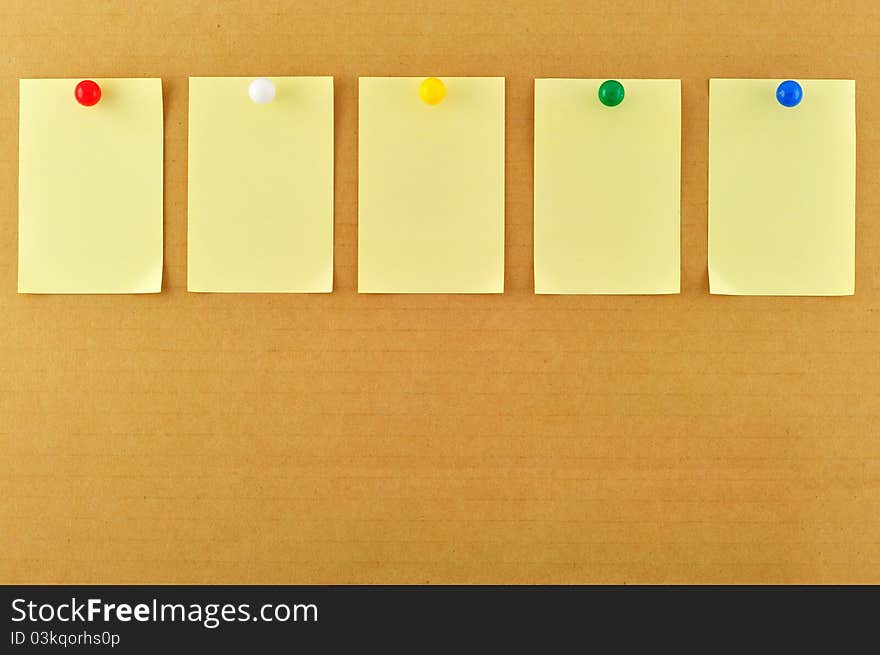 Blank sticky notes pinned on cardboard