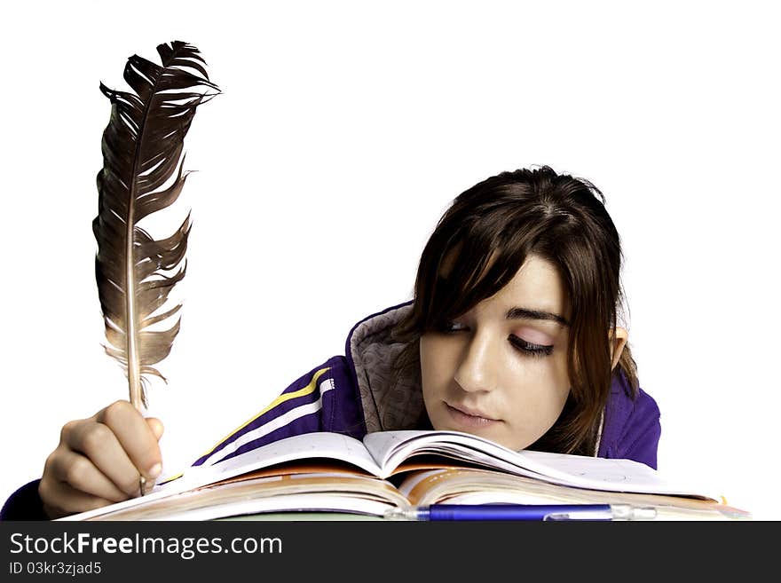 View of a teenager school girl writing on the book with a feather pen. View of a teenager school girl writing on the book with a feather pen.