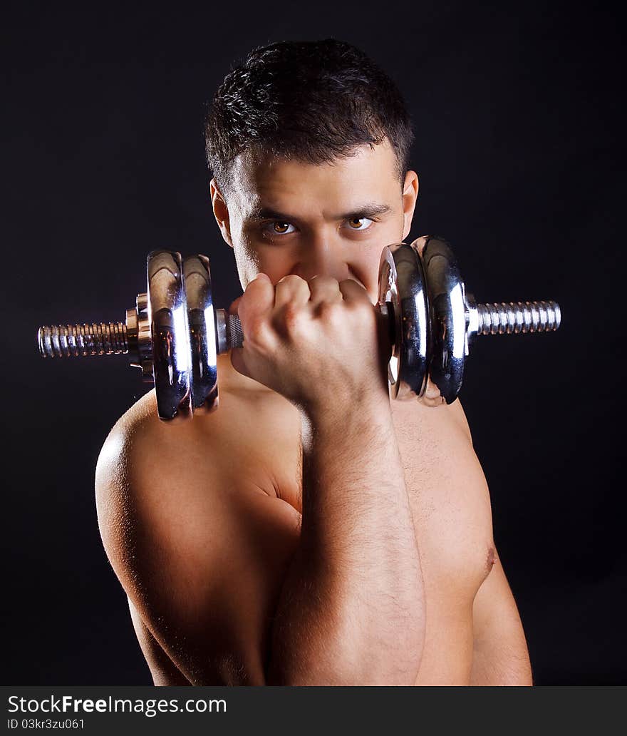 Handsome athlete is lifting dumbbells. Handsome athlete is lifting dumbbells