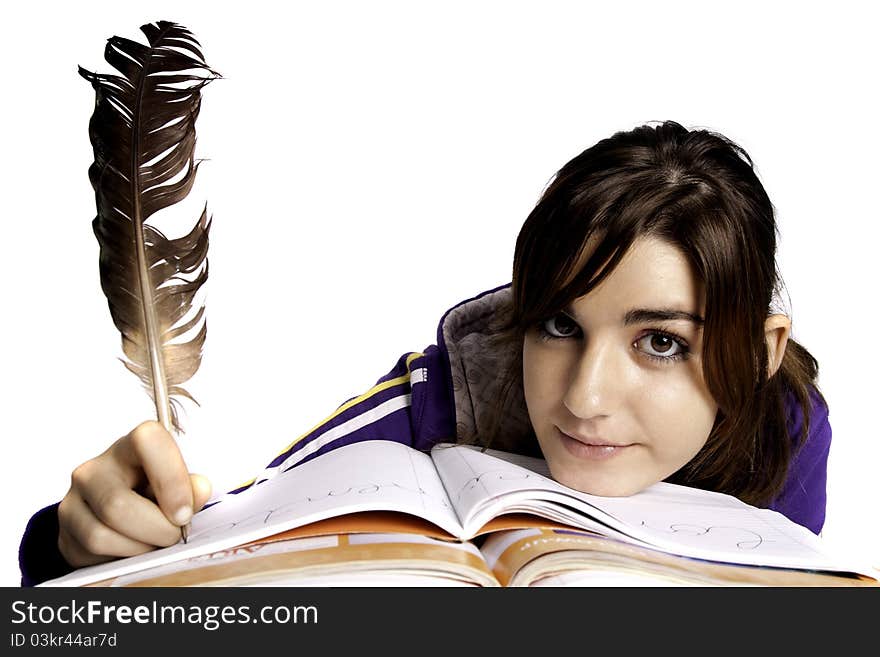 View of a teenager school girl writing on the book with a feather pen. View of a teenager school girl writing on the book with a feather pen.