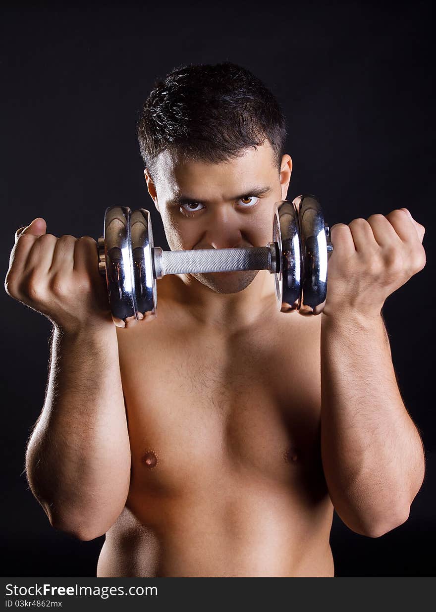 Young athlete is posing with weights. Young athlete is posing with weights