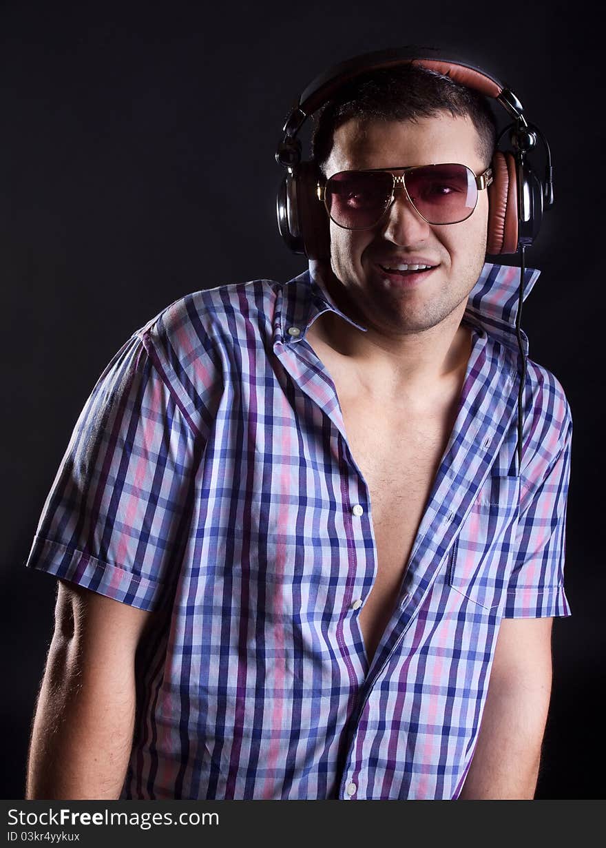 Man is wearing sunglasses and headphones. Man is wearing sunglasses and headphones