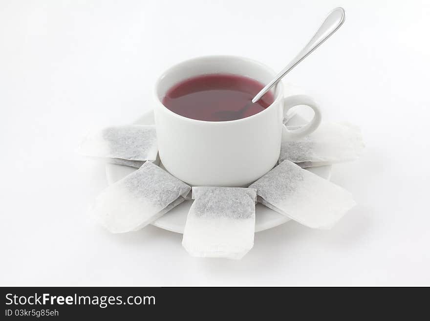 A cup of tea with teabags and spoon isolated on white. A cup of tea with teabags and spoon isolated on white