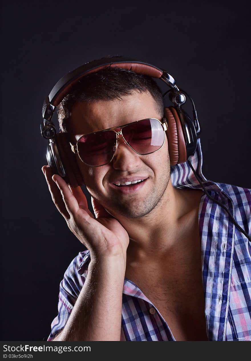 Man is wearing sunglasses and listening music. Man is wearing sunglasses and listening music