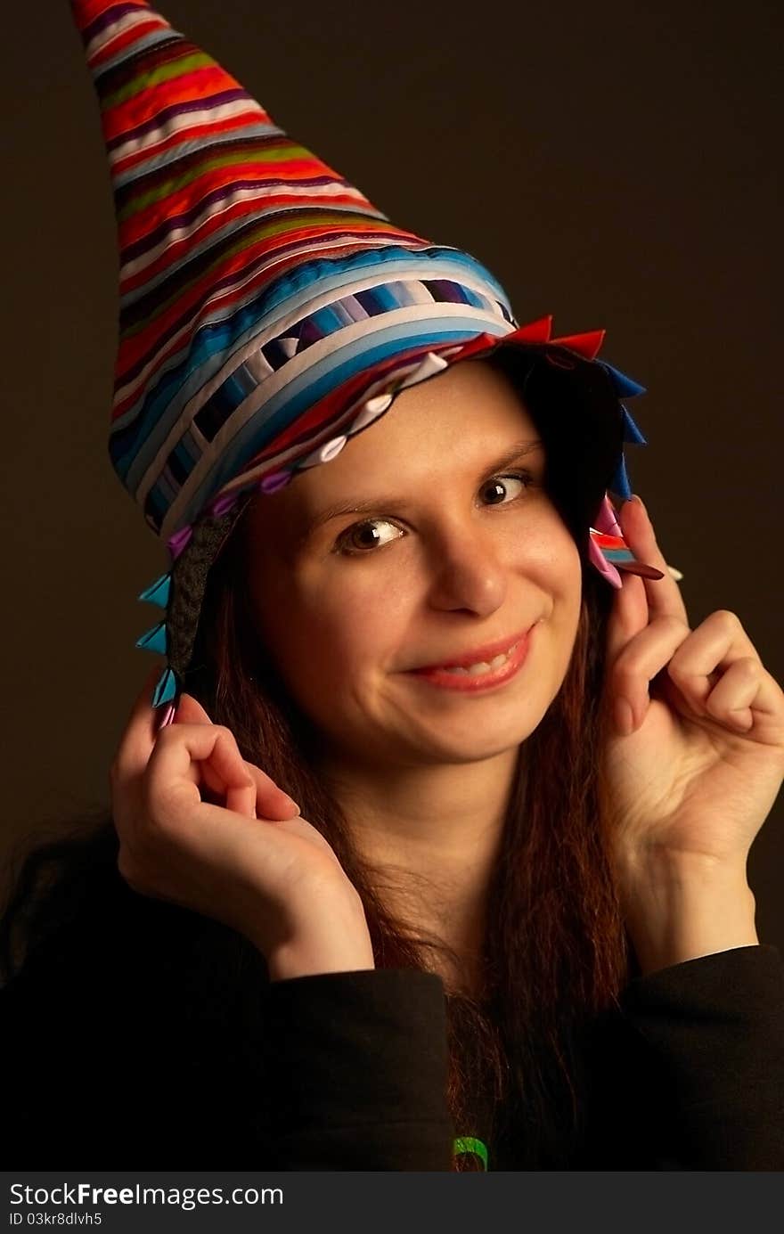 Studio portrait of young happy girl in multicolor fool's cap. Studio portrait of young happy girl in multicolor fool's cap