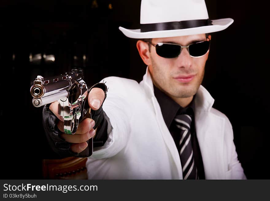 View of a white suit gangster man holding a gun. View of a white suit gangster man holding a gun.