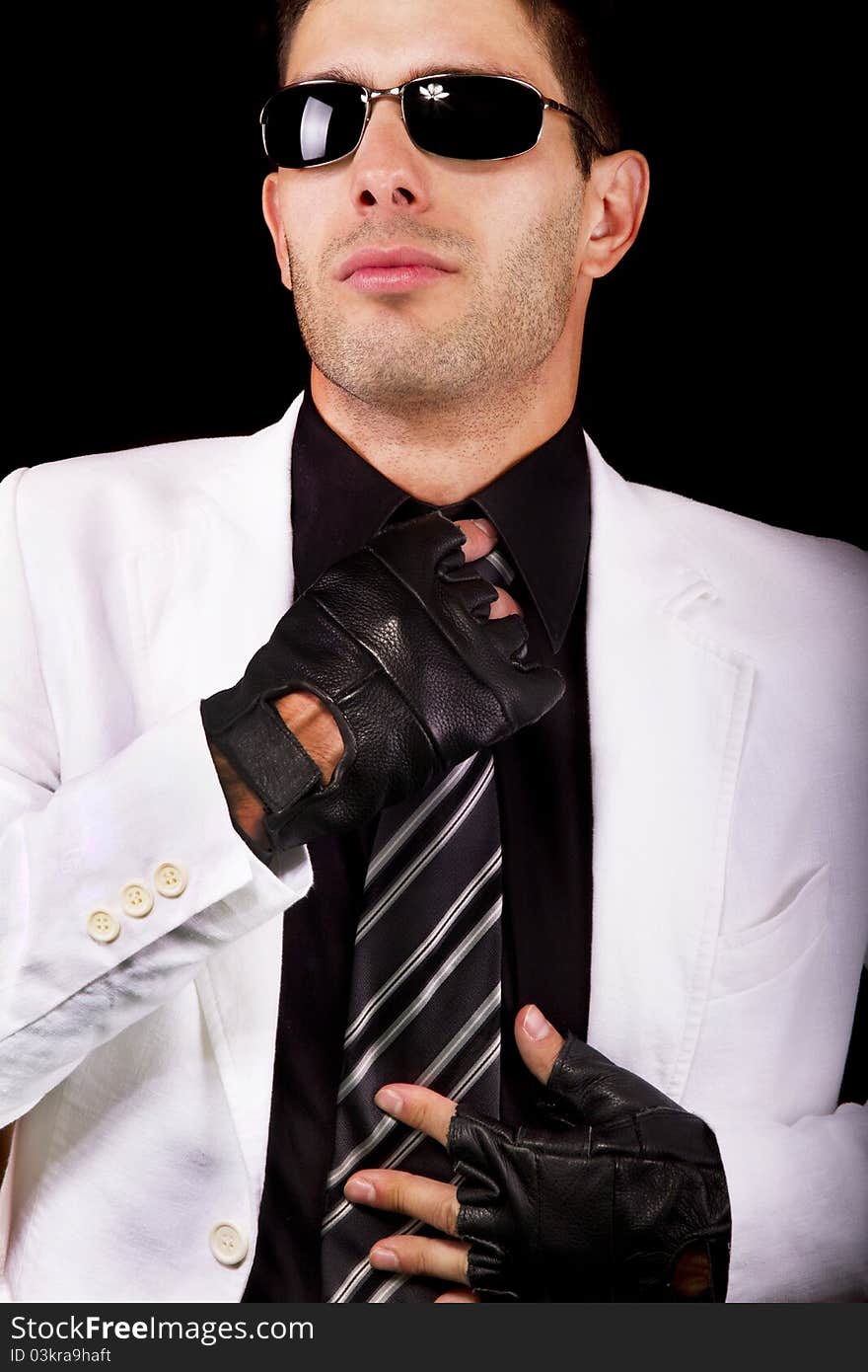 View of a white suit man with gloves, adjusting a tie. View of a white suit man with gloves, adjusting a tie.