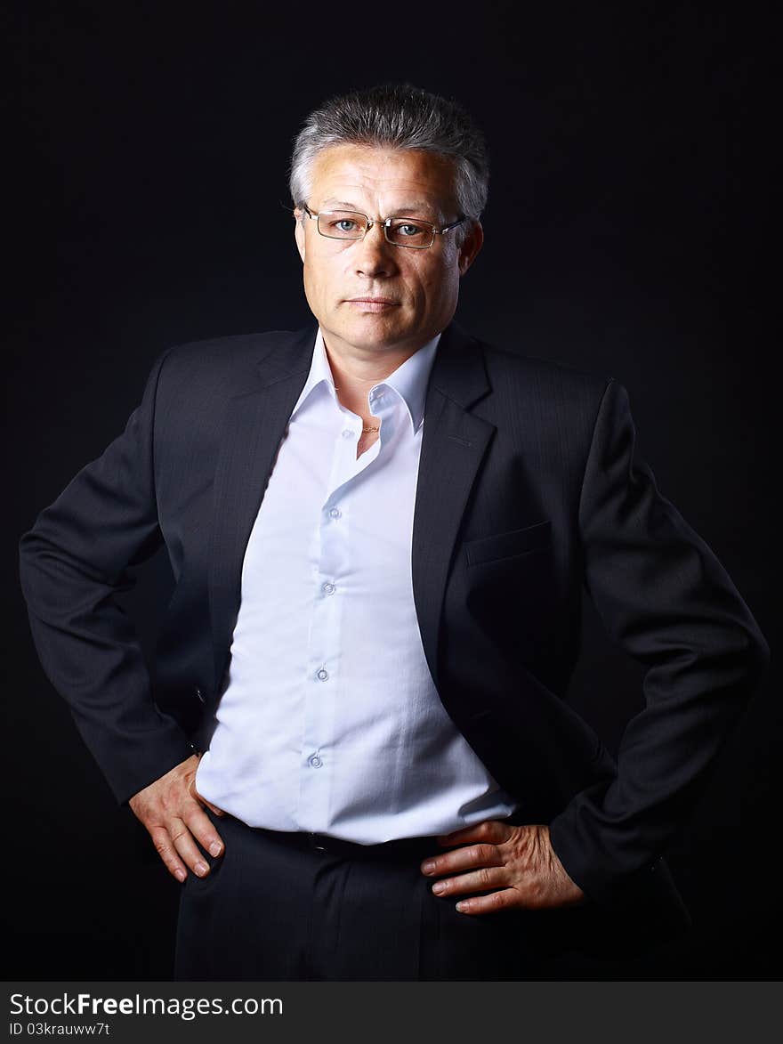 Portrait of successful business man standing on black background. Portrait of successful business man standing on black background