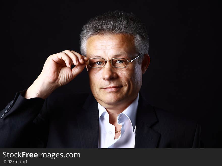 Portrait of successful business man standing on black background. Portrait of successful business man standing on black background