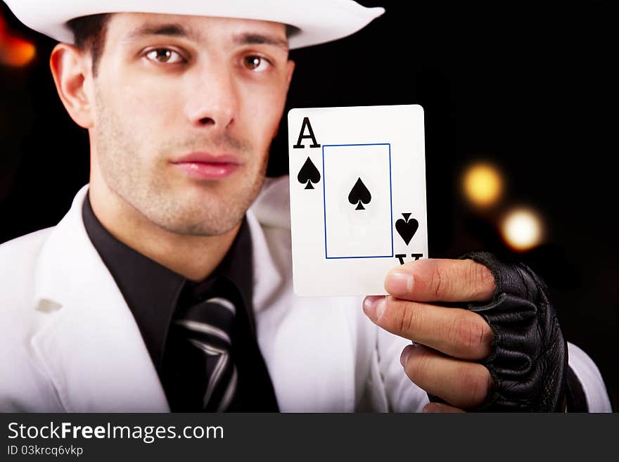 View of a white suit man with hat, holding an ace card.