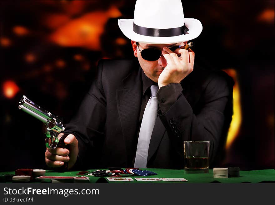 View of a gangster man playing some cards and poker. View of a gangster man playing some cards and poker.