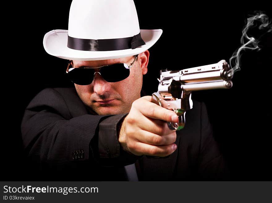 View of a white suit gangster man holding a gun. View of a white suit gangster man holding a gun.