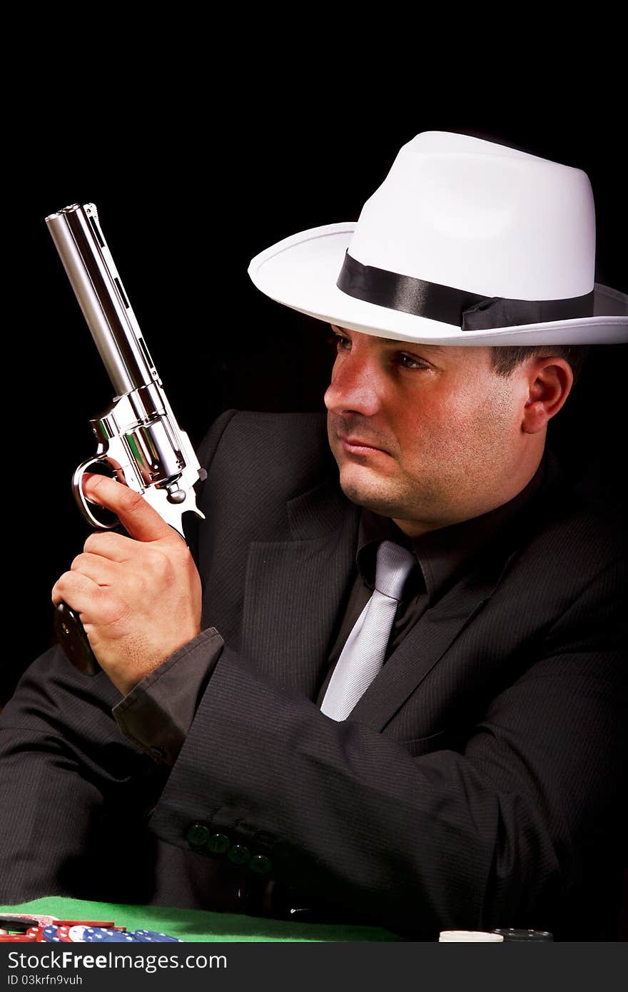 View of a dark suit gangster man holding a gun. View of a dark suit gangster man holding a gun.