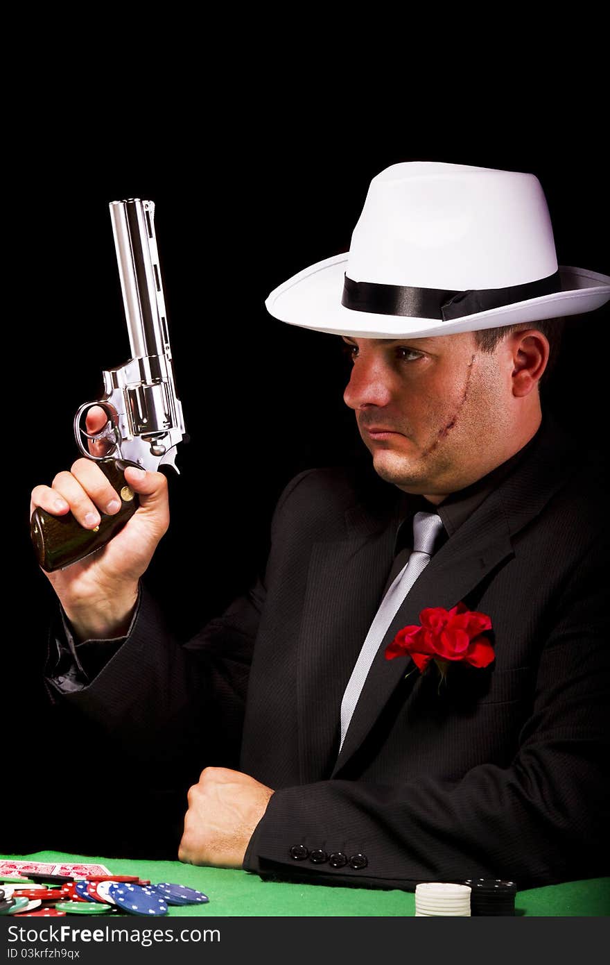 View of a dark suit gangster man holding a gun. View of a dark suit gangster man holding a gun.