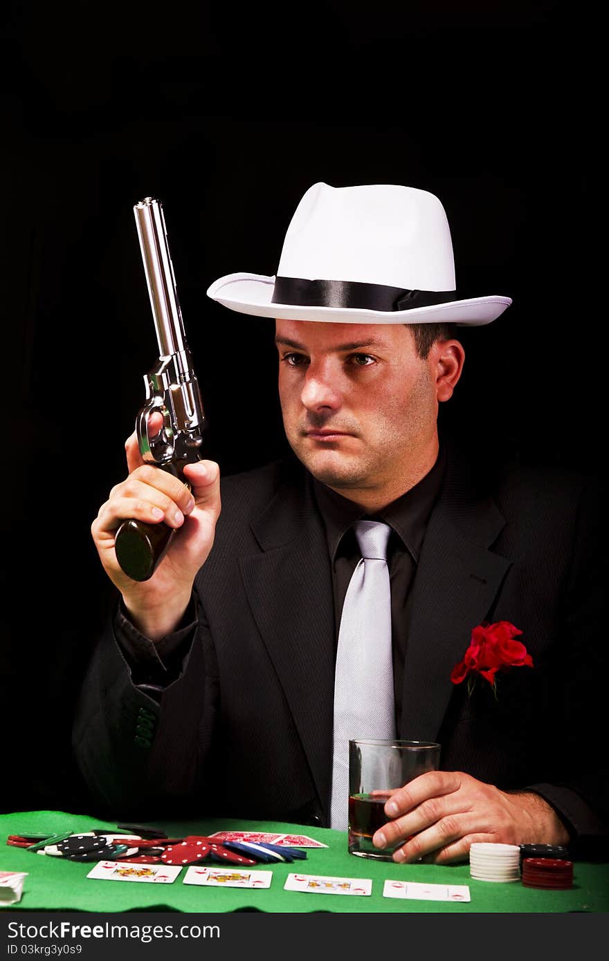 View of a dark suit gangster man holding a gun. View of a dark suit gangster man holding a gun.