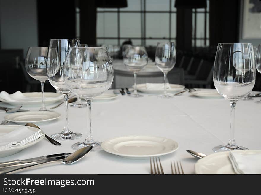 Wineglass and plates on table.