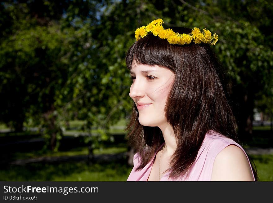 The portrait of the young beautiful girl in park, smiles