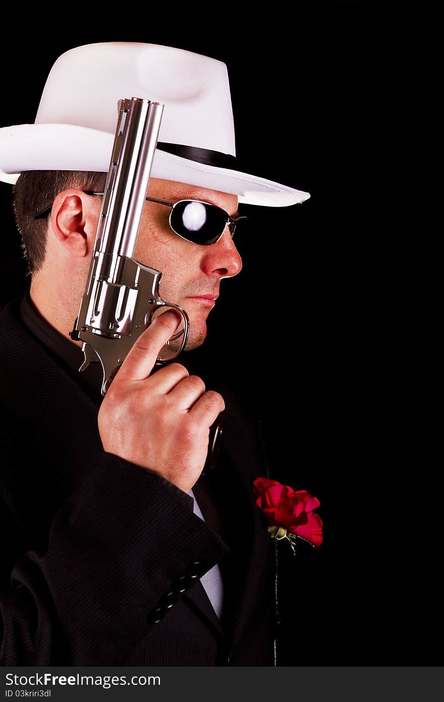 View of a dark suit gangster man holding a gun. View of a dark suit gangster man holding a gun.