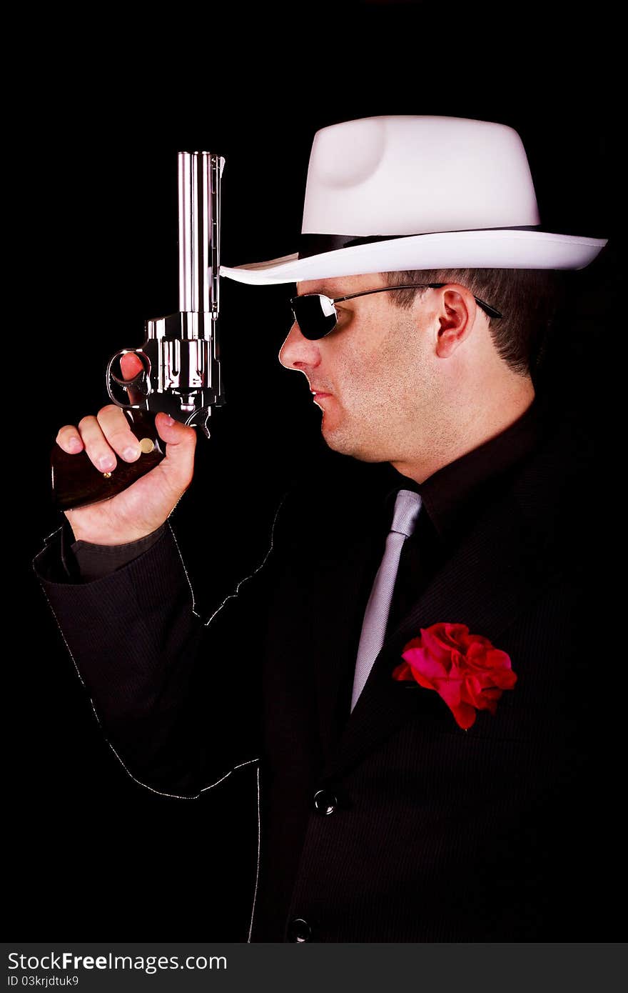 View of a dark suit gangster man holding a gun. View of a dark suit gangster man holding a gun.