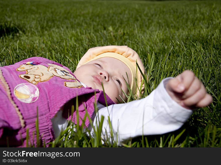 The portrait of the kid, lays on grass