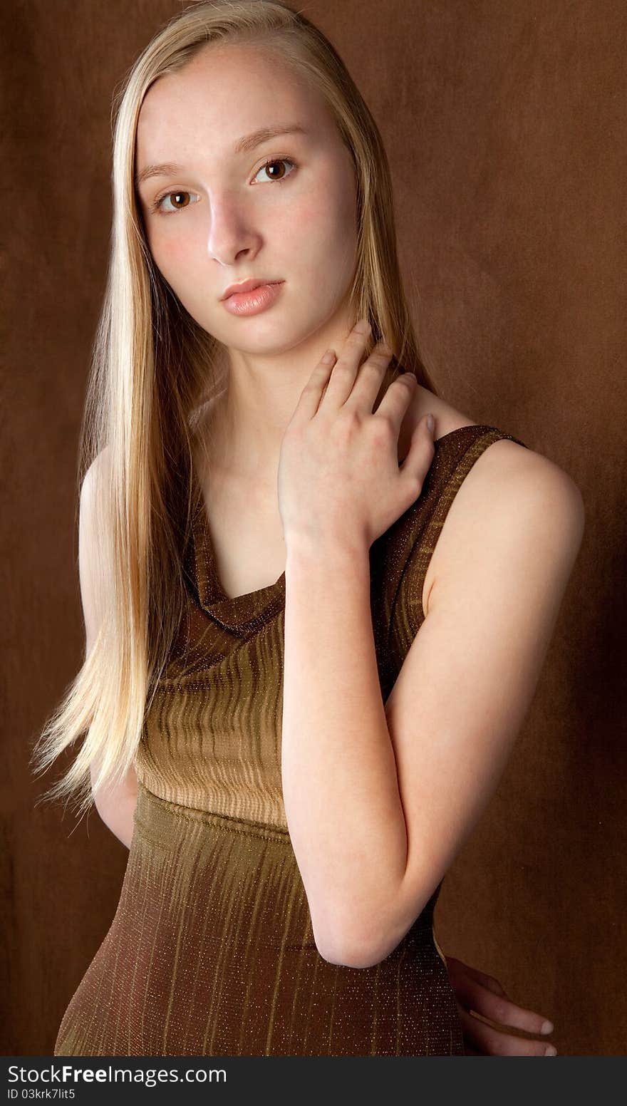 A portrait of a lovely teenager wearing a brown dress against a brown background. A portrait of a lovely teenager wearing a brown dress against a brown background