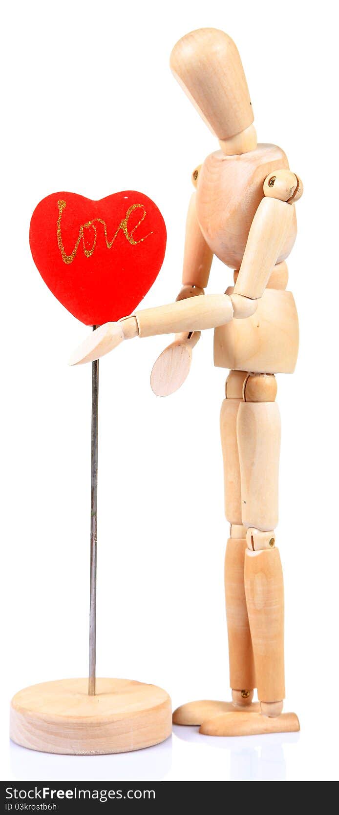 Wooden mannequin holding heart over white background. Wooden mannequin holding heart over white background.