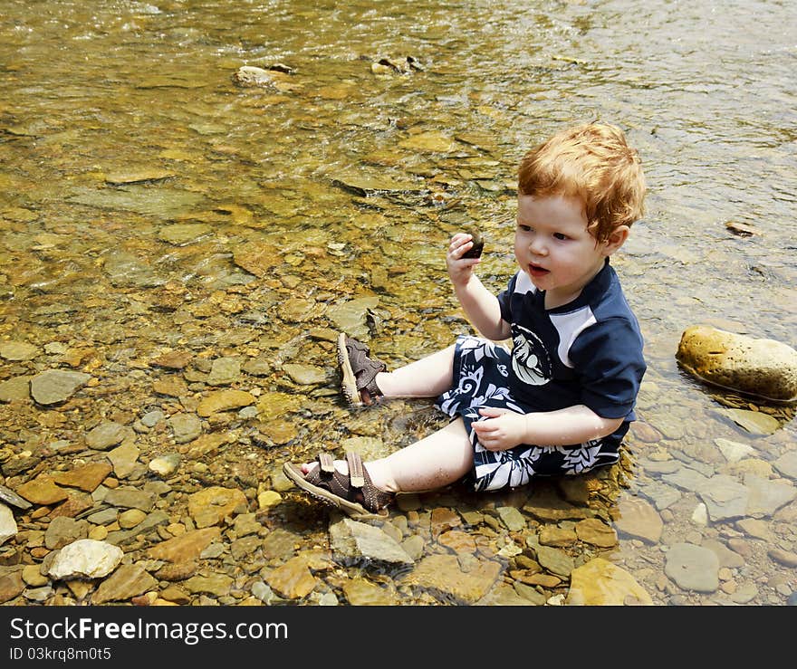 Young toddler playing in the water. Young toddler playing in the water.