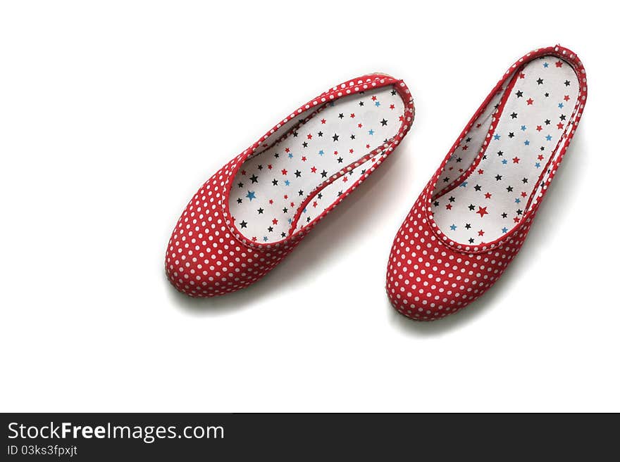 A pair of stylish flat shoes, with polkadotted pattern, isolated on white background.