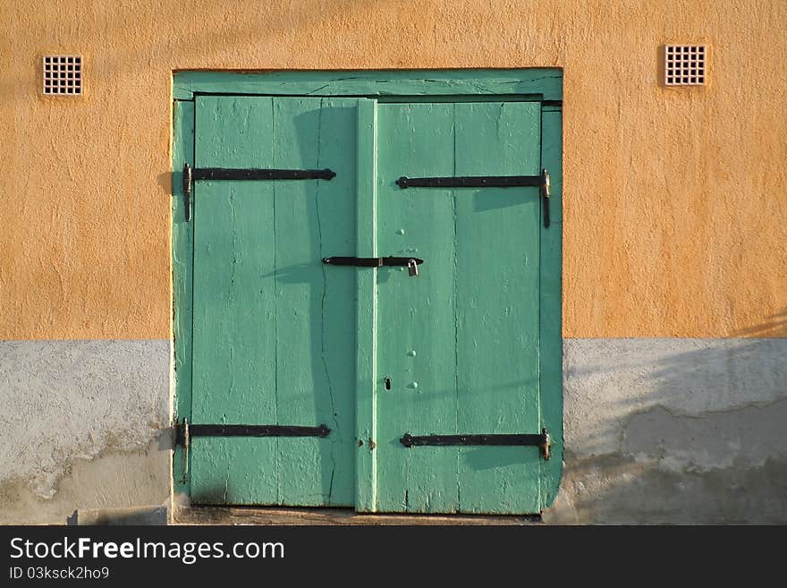 Green wooden door in sunshine