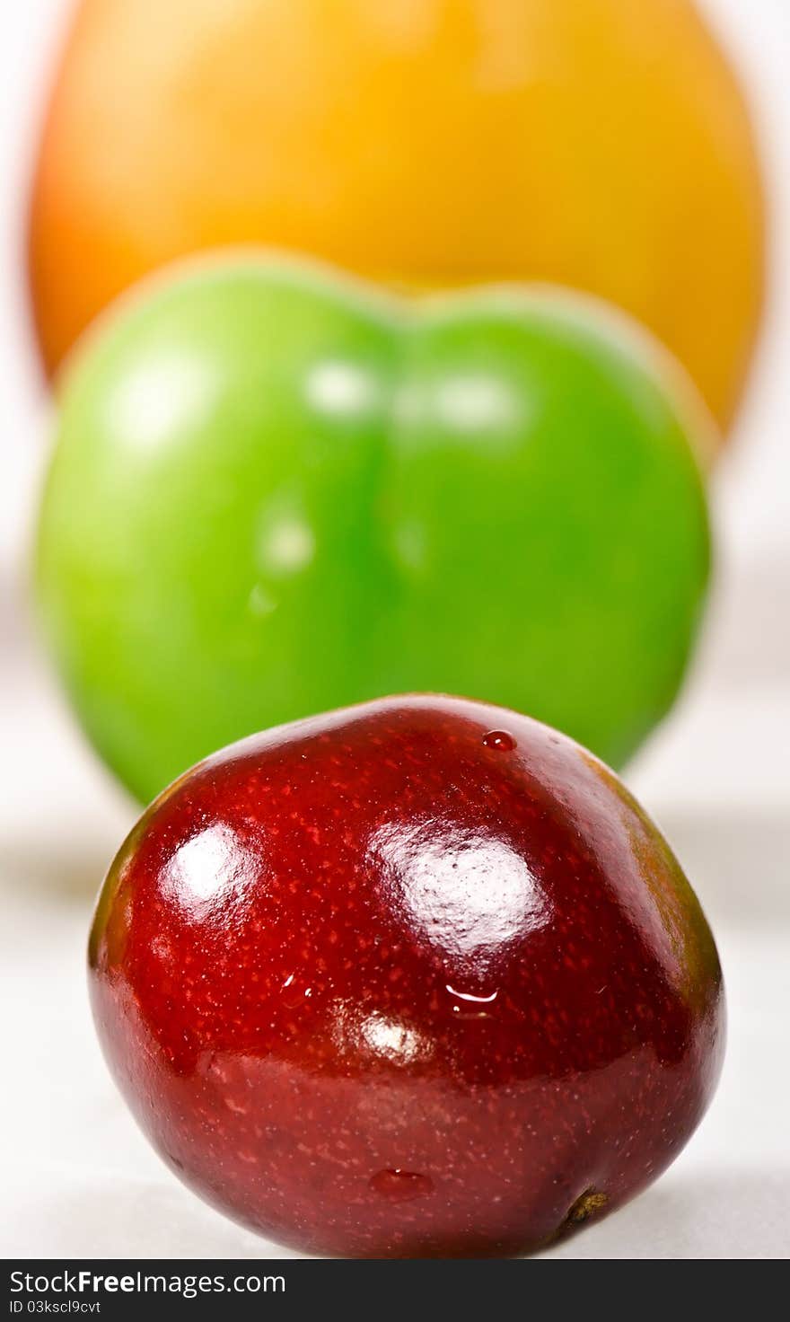 Three in a row; cherry, plum and apricot on a white background