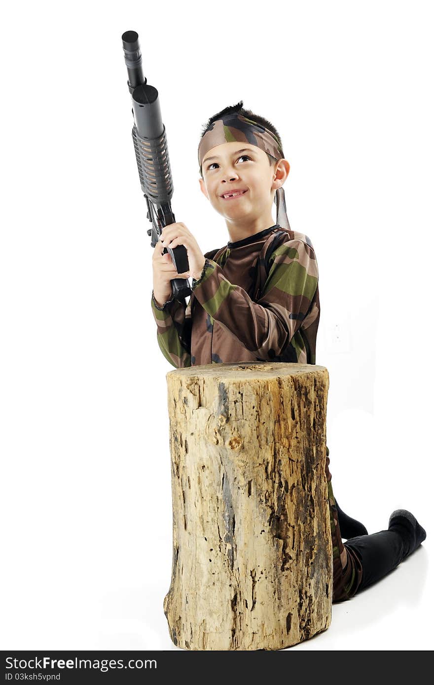 A young elementary soldier in army camouflage, poised with his machine gun behind an old tree stump. Isolated on white. A young elementary soldier in army camouflage, poised with his machine gun behind an old tree stump. Isolated on white.