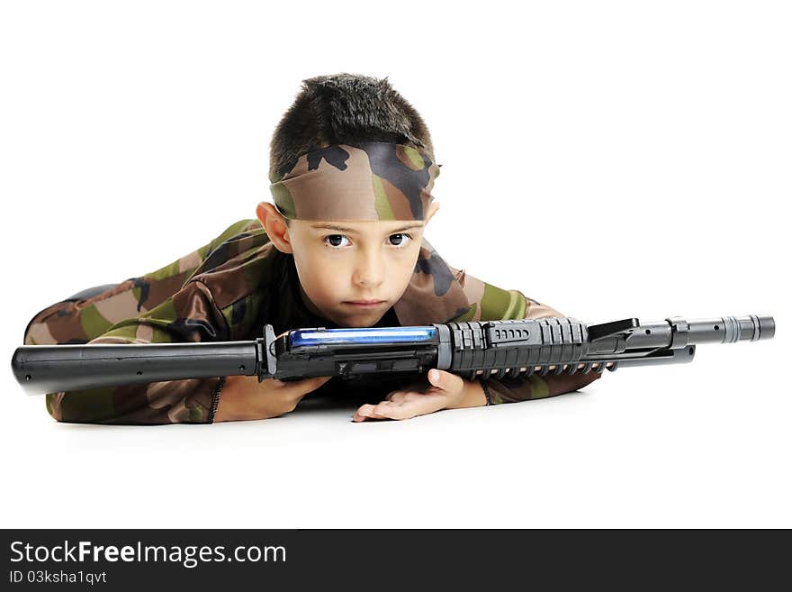 A serious young boy in army camoflage, crawling on his belly with a black machine gun. Isolated on white. A serious young boy in army camoflage, crawling on his belly with a black machine gun. Isolated on white.