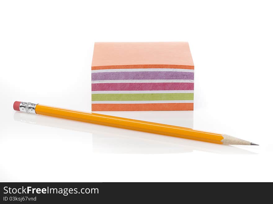 A colorful note pad with a pencil against a white background