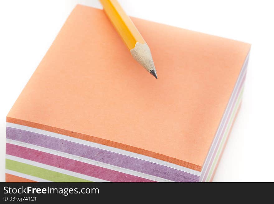 A colorful note pad with a pencil against a white background