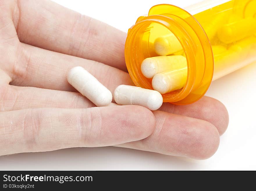 White pills pouring into a persons hand