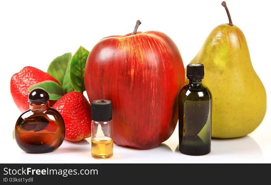 Fruit essence bottles with fruits over white background.