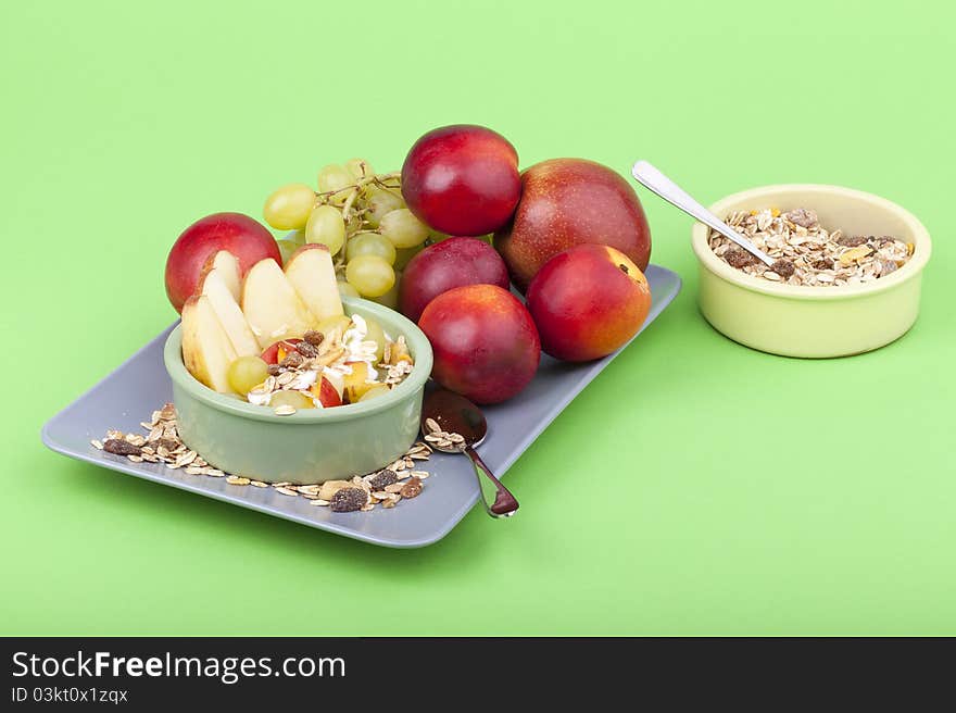 Studio-shot of a plate with fresh fruits, muesli and yogurt. bowl full with grapes, nectarines and apple. Studio-shot of a plate with fresh fruits, muesli and yogurt. bowl full with grapes, nectarines and apple.