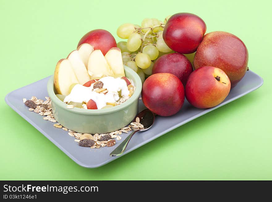 Studio-shot of a plate with fresh fruits, muesli and yogurt. plate full with grapes, nectarines and apple. Studio-shot of a plate with fresh fruits, muesli and yogurt. plate full with grapes, nectarines and apple.